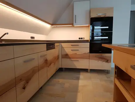 Durchlaufende Massivholzfront in unseren Küchen  