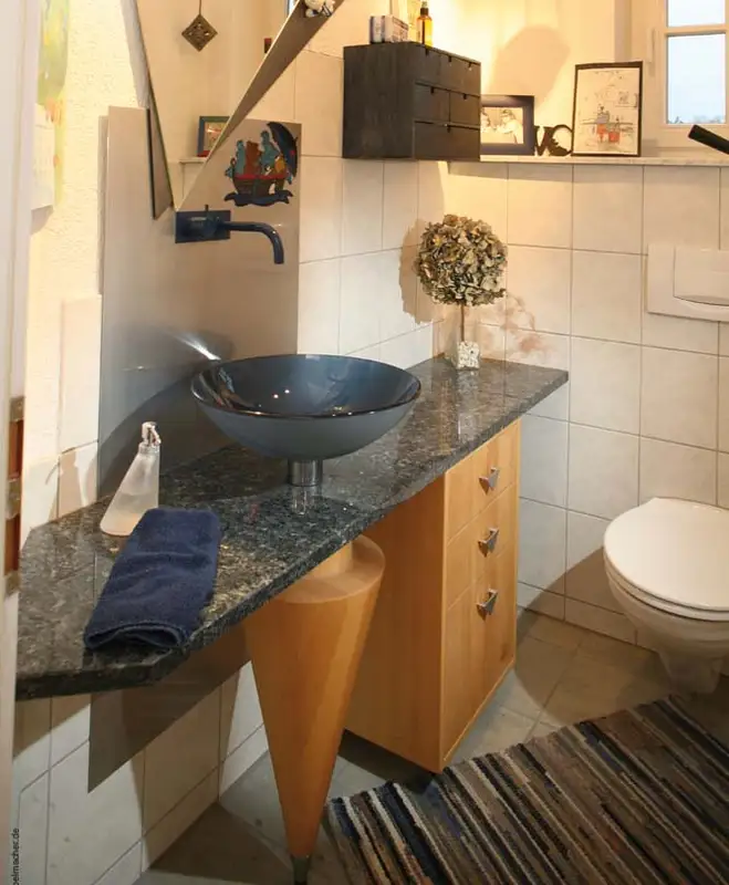 Gedrechselte Massivholzsäule unter Granitwaschtisch