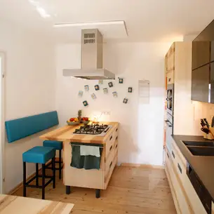 Kochinsel mit Hockern und Lehne an der Wand 